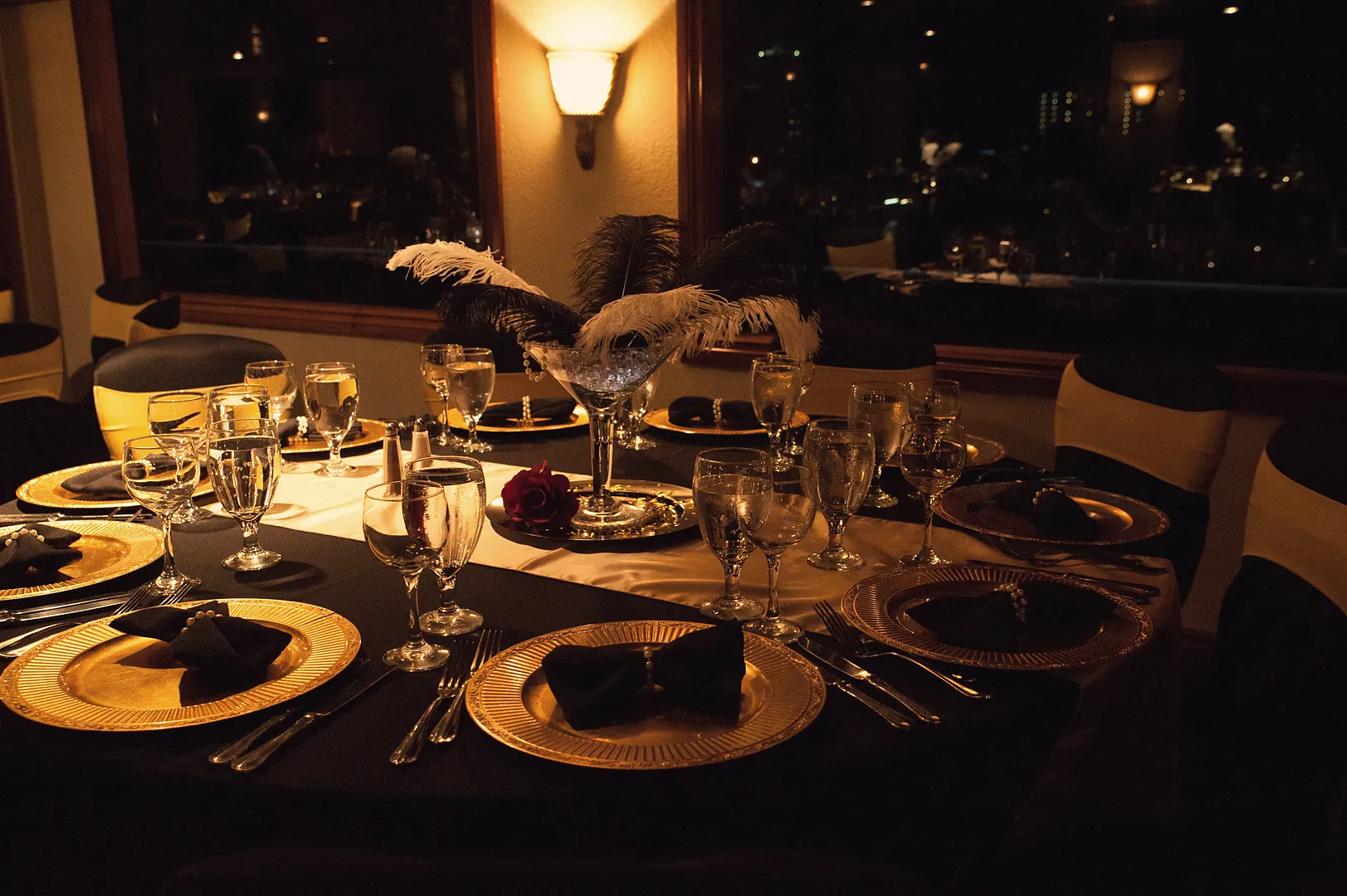 Candlelit black-and-gold dinner tables set for a corporate holiday gala