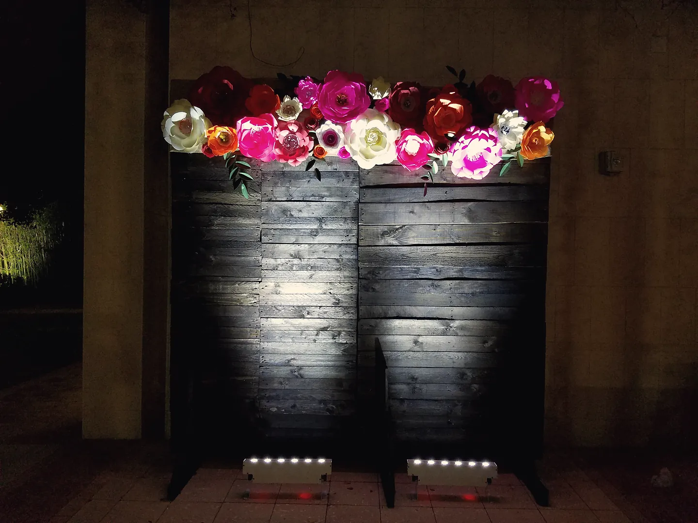 Illuminated rose arrangements glowing at an evening birthday celebration