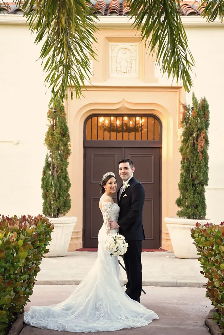 Bride and groom framed by a grand arched doorway at a South Florida estate